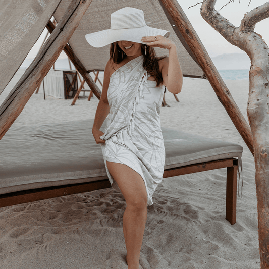 Woman wears a Turkish towel as a sarong at the beach. Luxury