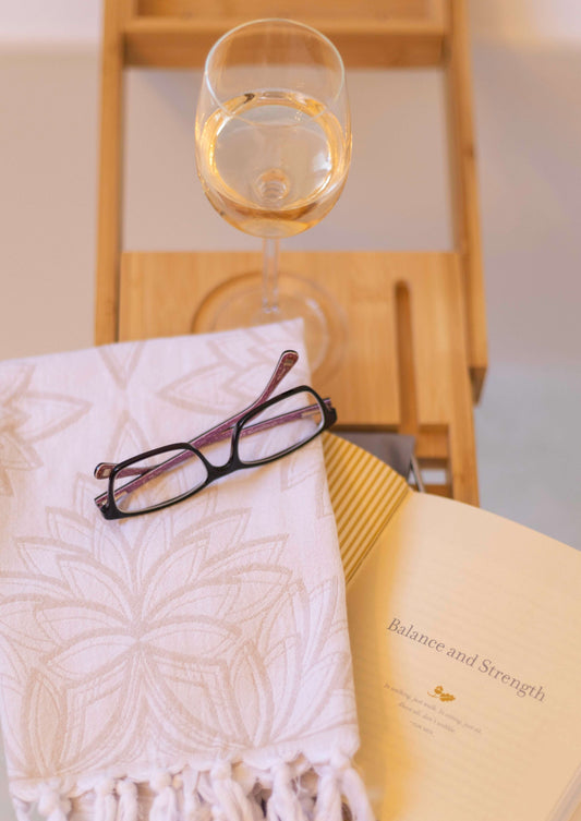 Turkish towel in the bath with a book and wine
