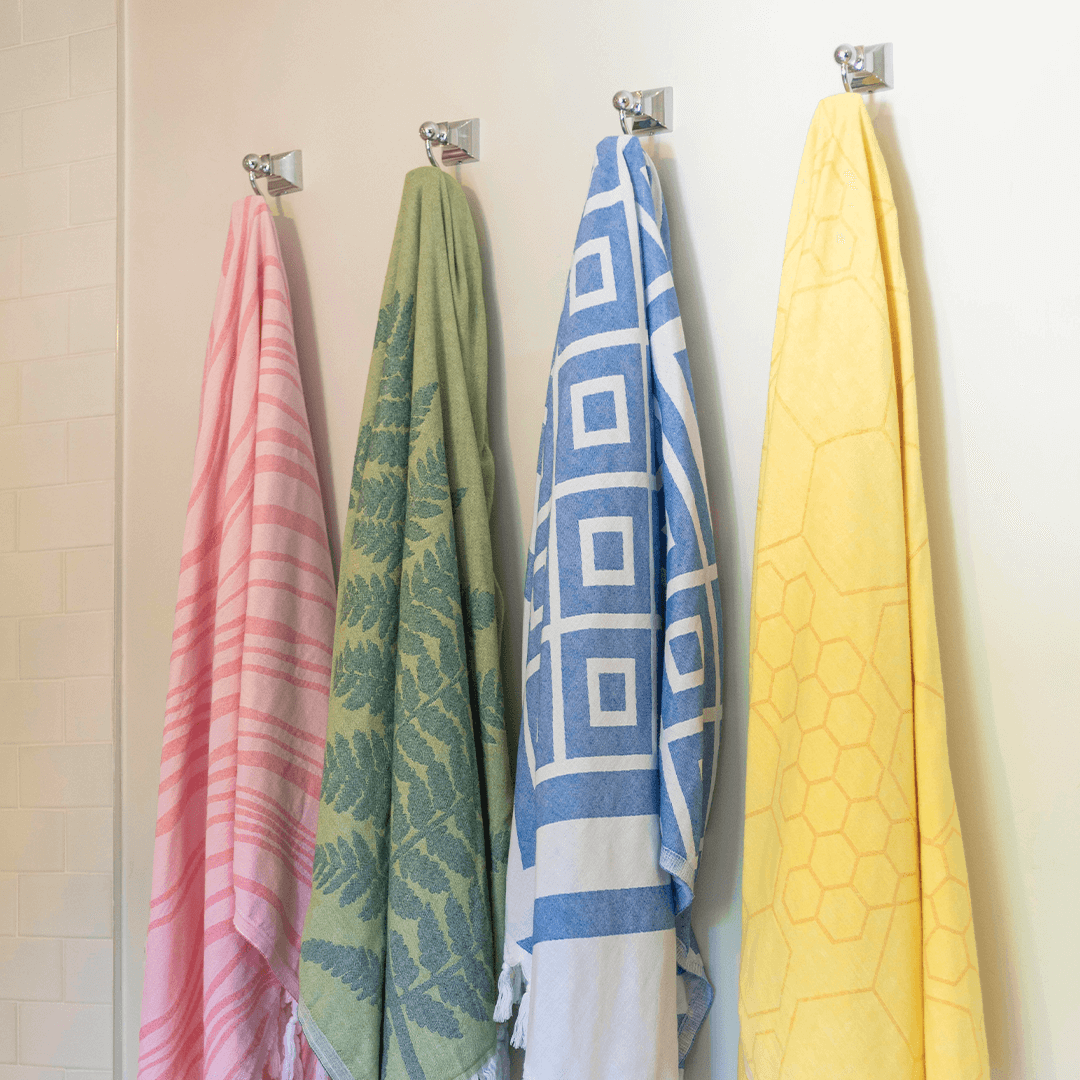 Pink, green, blue and yellow Turkish towels on hooks. Canadian brand