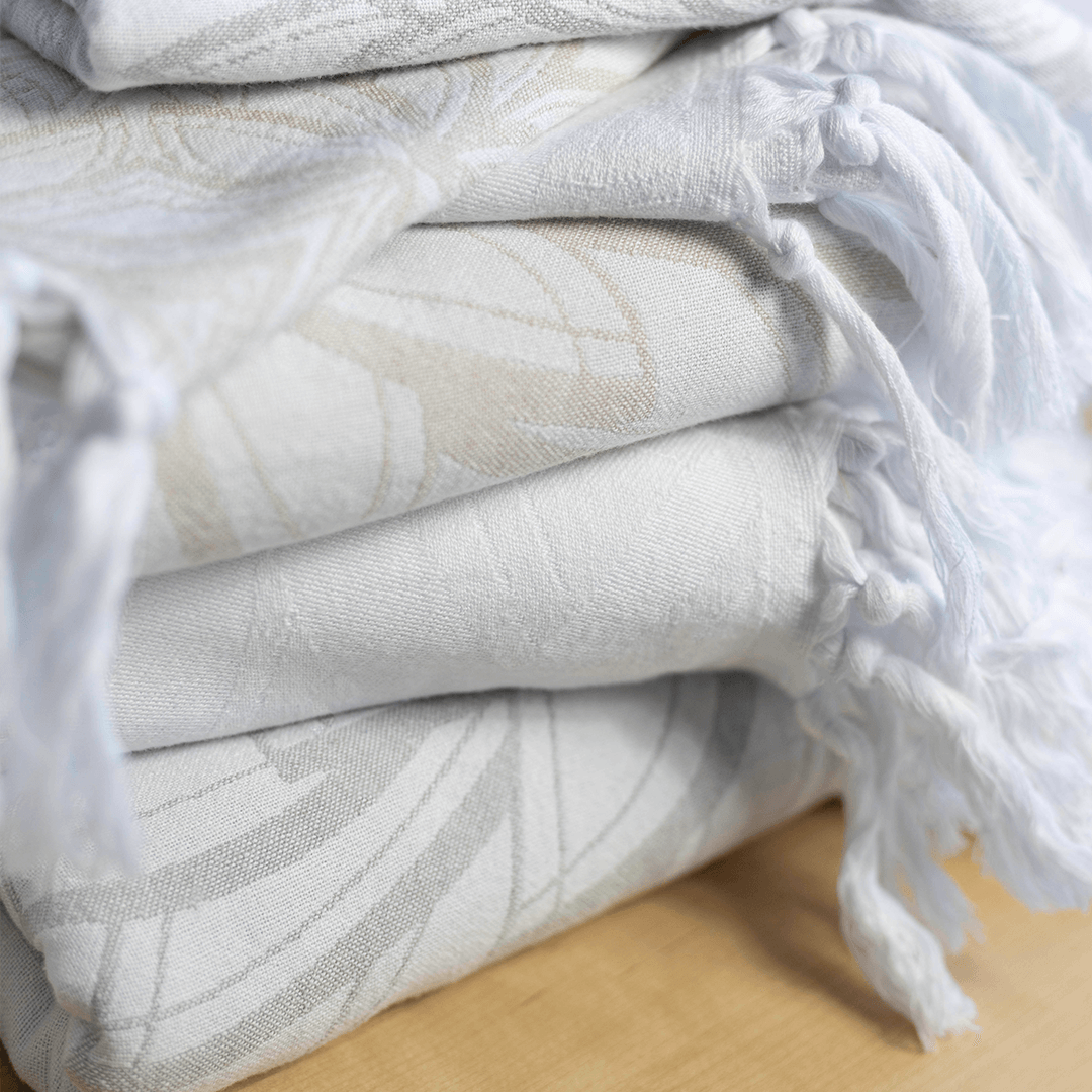 A stack of cream coloured Lotus designed Pomp & Sass Turkish towels.