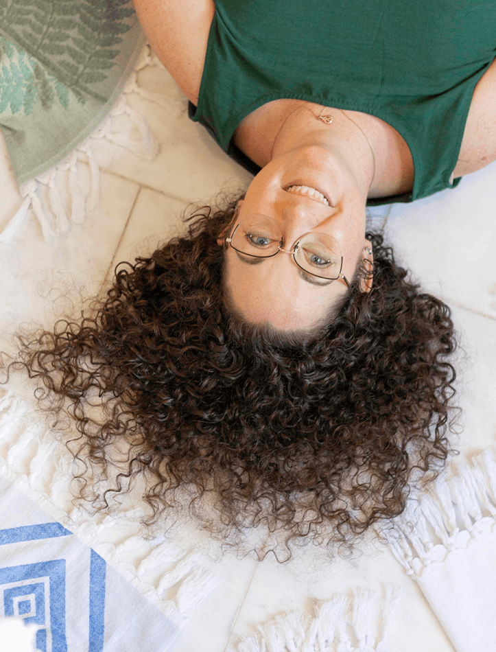Founder of Pomp & Sass Nikky Starrett smiles with her Turkish towels and her curly hair