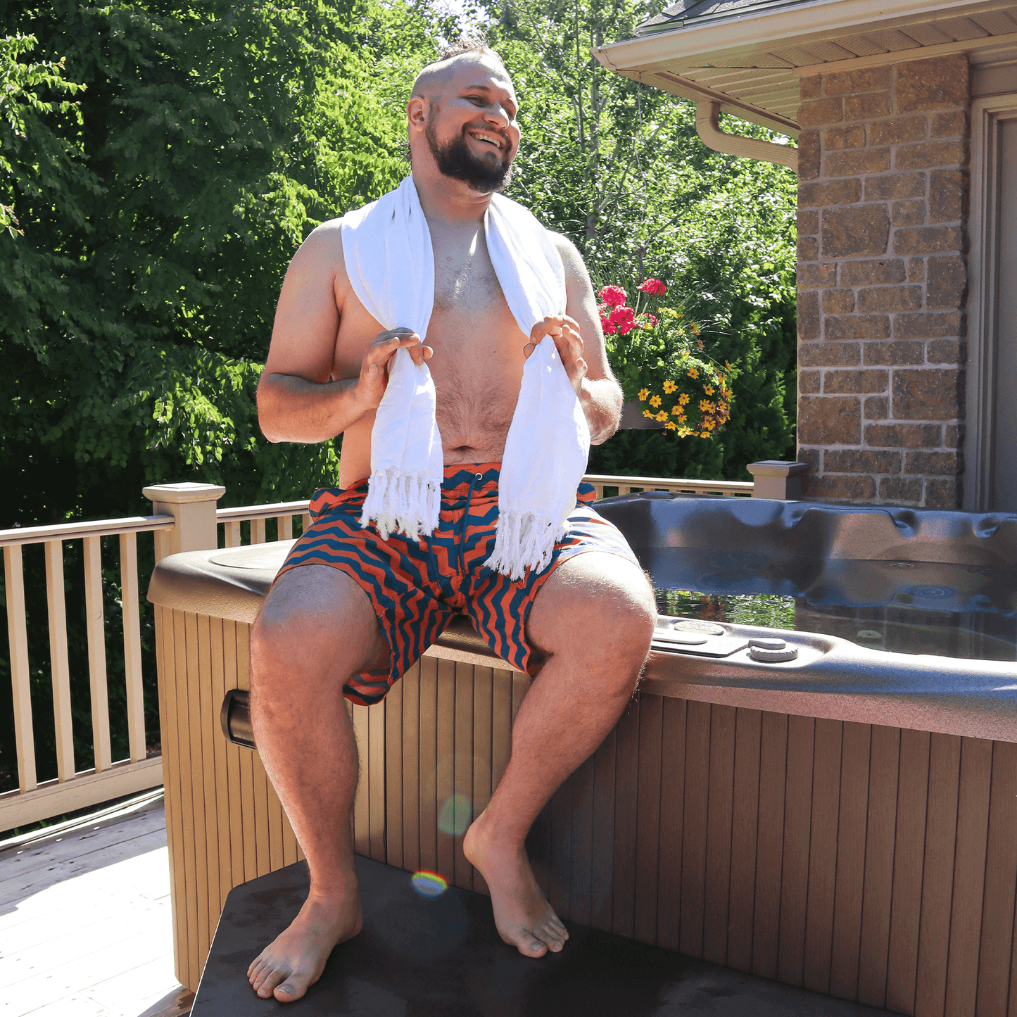 smiling man using a white Turkish towel at the hot tub