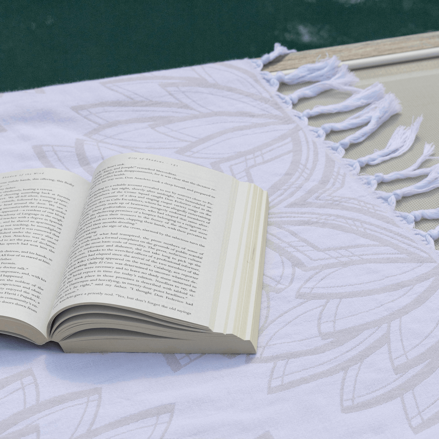 Turkish towel poolside with a book