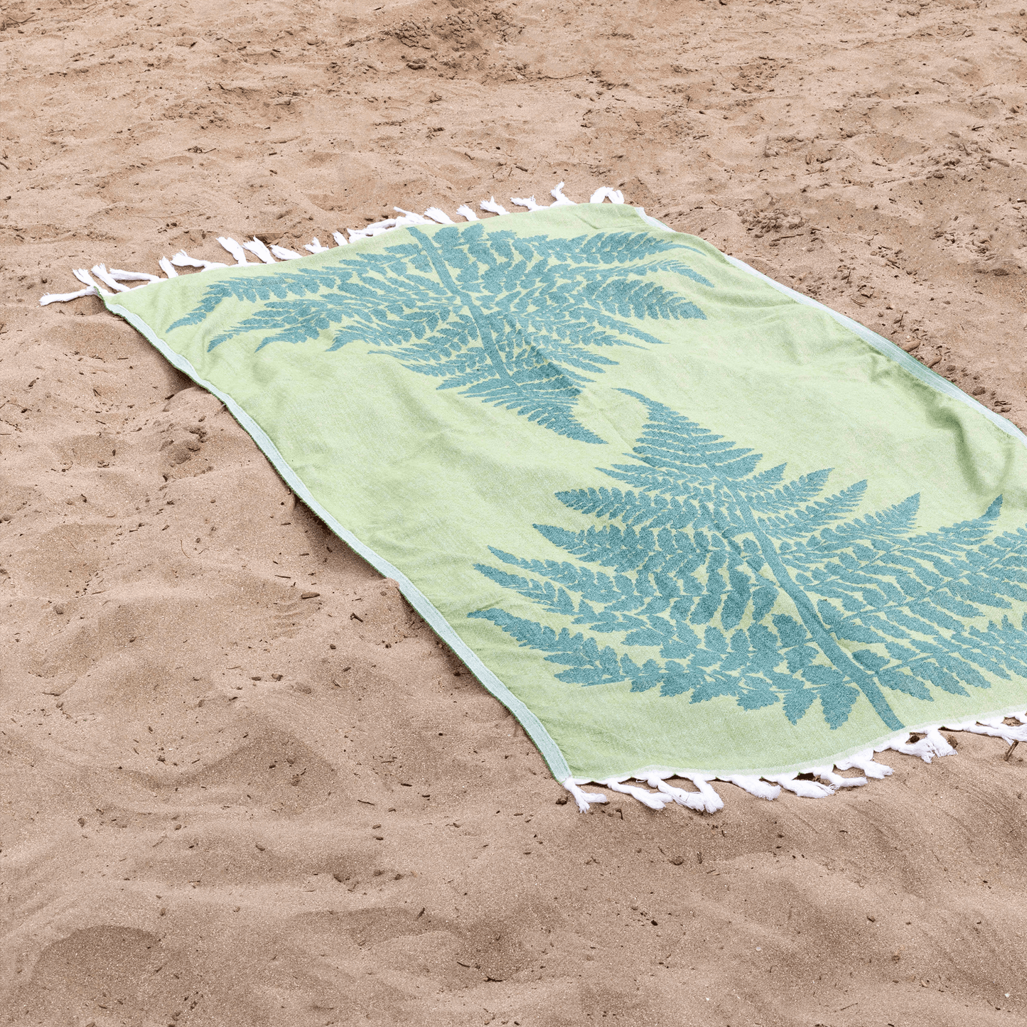 green Turkish towel at the beach