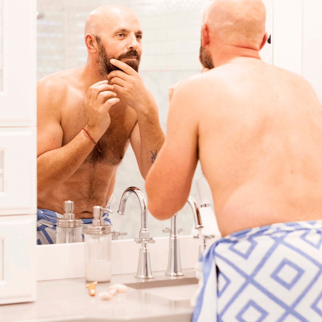 Shirtless man using a Turkish towel in the bath