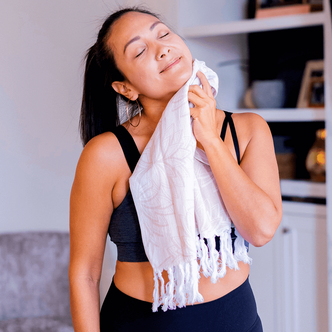 smiling woman using a Turkish towel after yoga