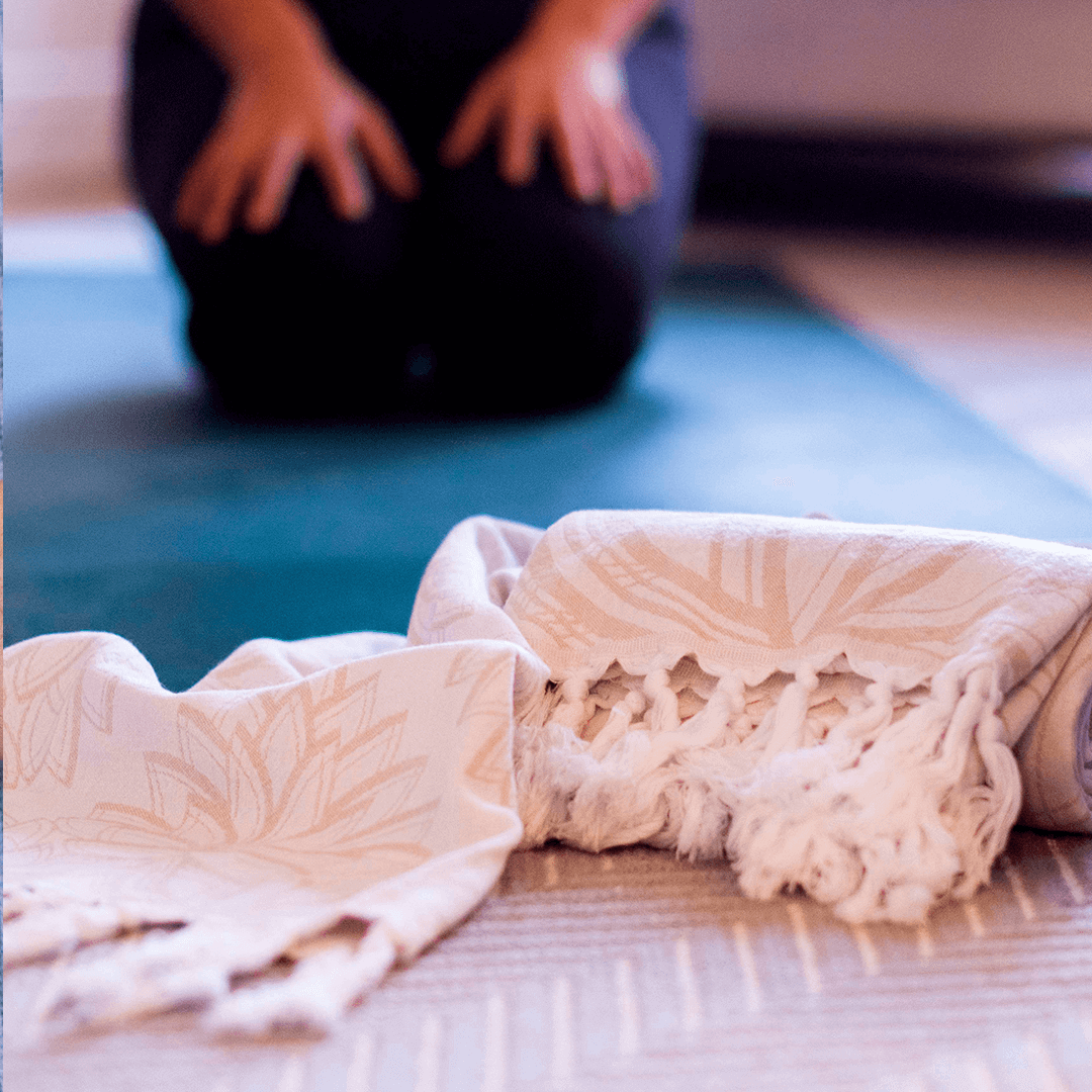 smiling woman using a Turkish towel after yoga