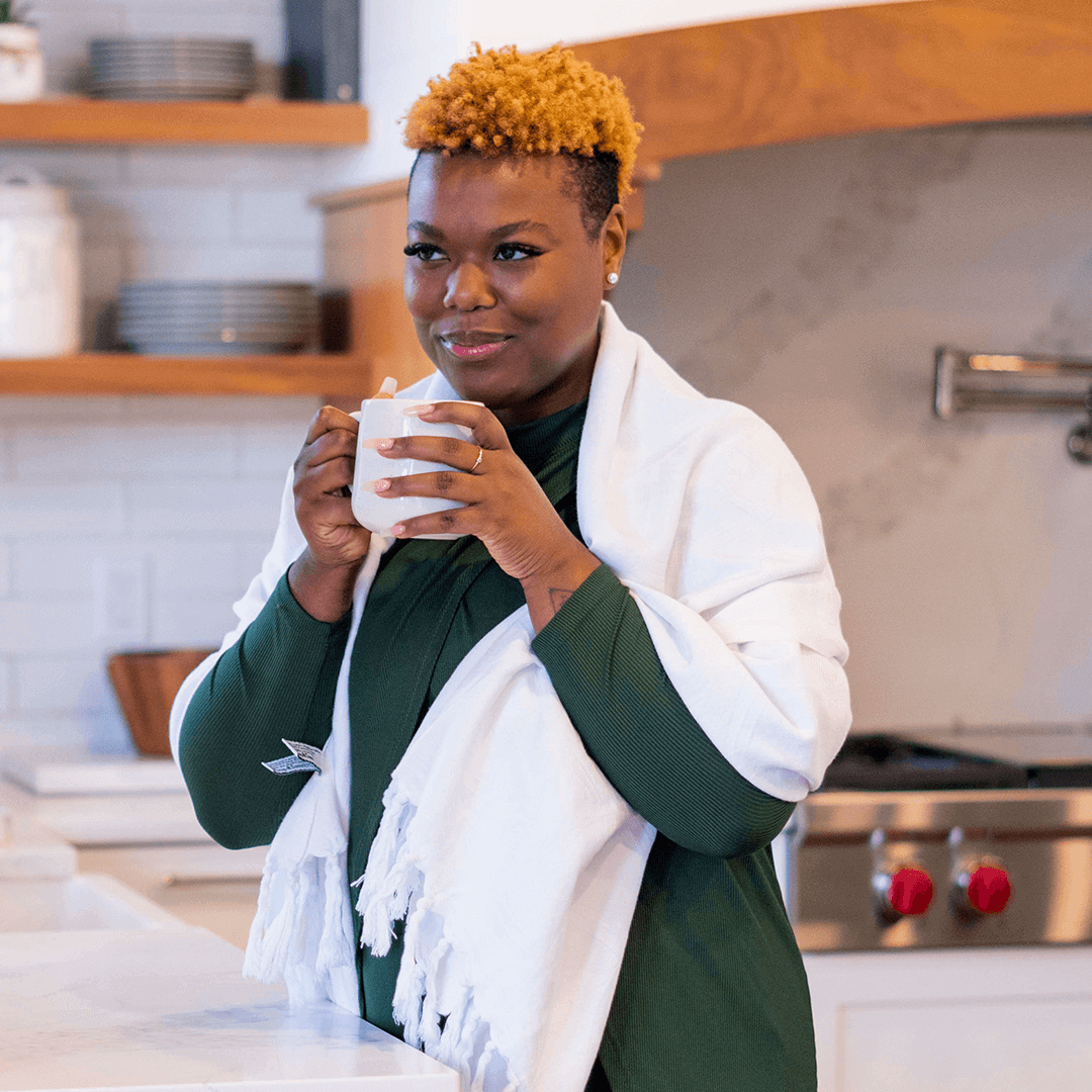 Black woman wearing a white Turkish towel as a shawl