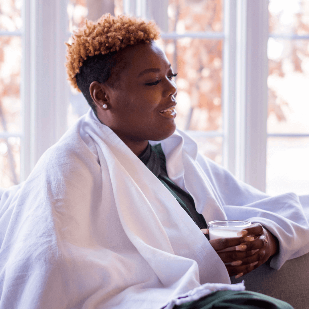 smiling woman using a white Turkish towel as a light blanket