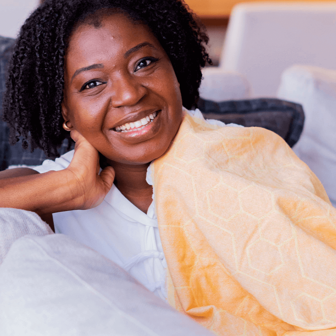 smiling woman using a Yellow orange honeycomb pattern Turkish towel with white tassels