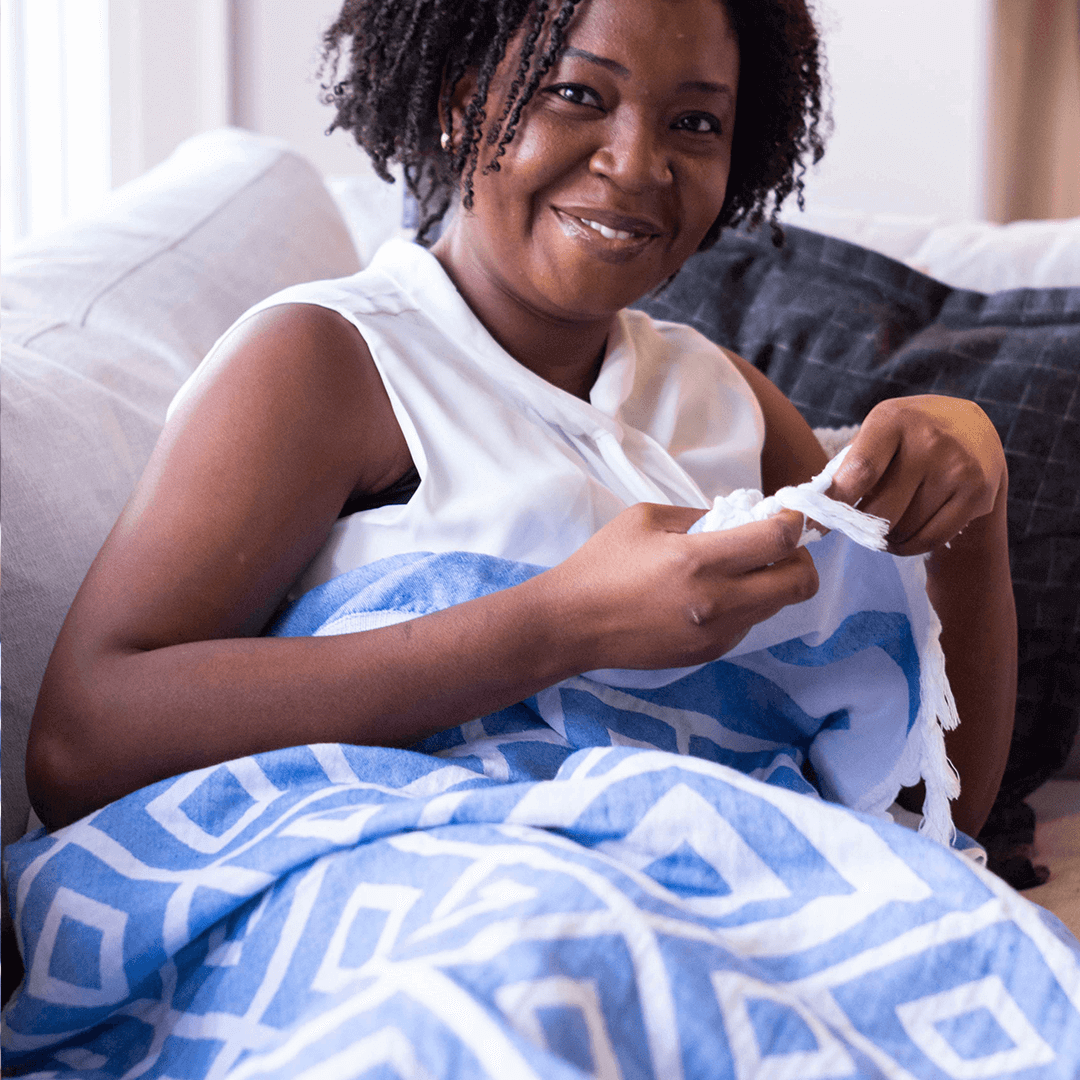 Woman using a blue and white Turkish towels as a blanket