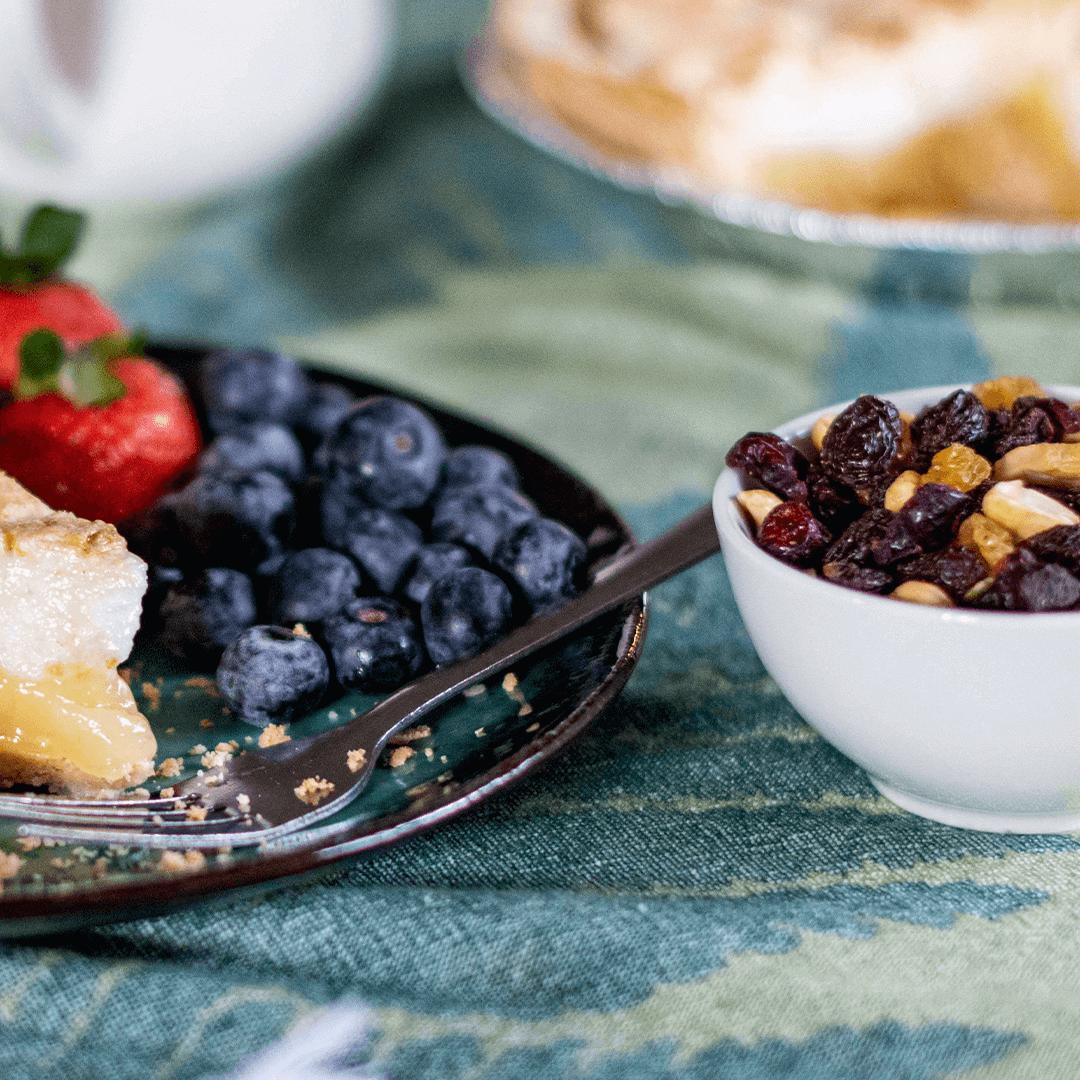 Green Turkish towel used as a tablecloth with strawberries blueberries and pie