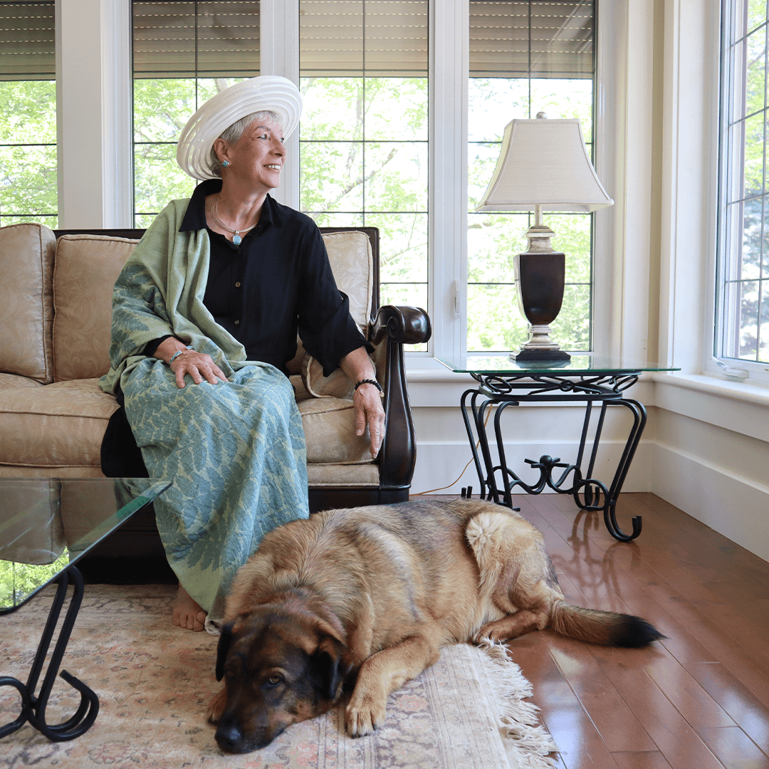Elderly woman uses her Turkish towel as a shawl accompanied by her dog