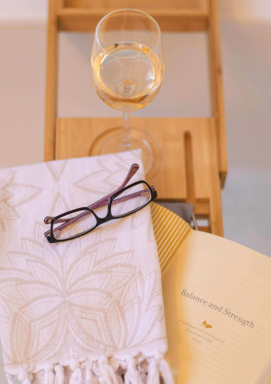 Turkish towel in the bath with a book and wine