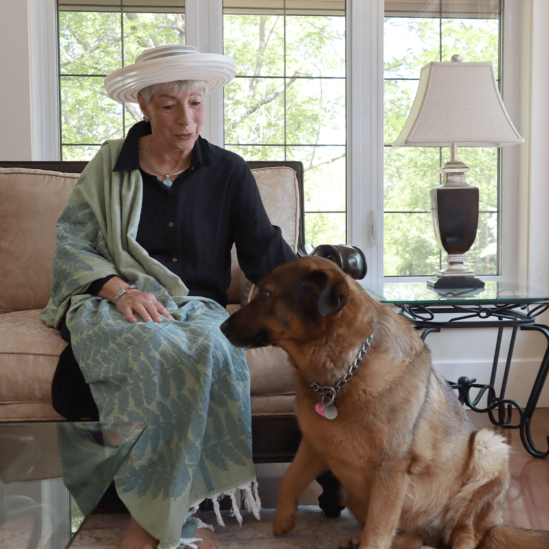 Elderly woman wearing a Turkish towel as a shawl. With her dog.