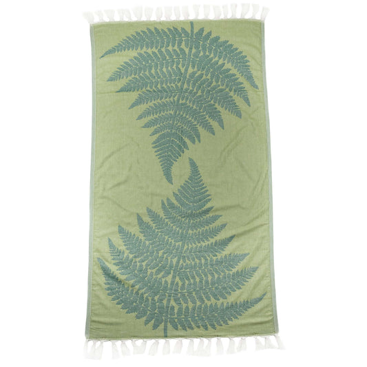 Green fern Turkish body towel as a flat image showing the full product. A green Turkish towel with a light green as the base and two darker green fern leaves pointing towards each other. White knotted tassels on both short ends.