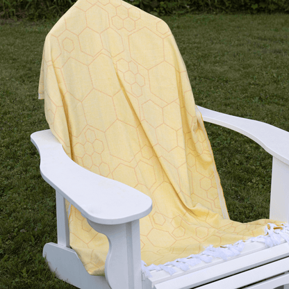 A large Turkish towel is spread across an annaron deck chair outside during the summer