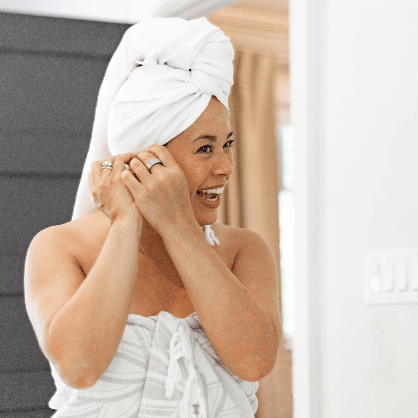 Smiling woman in a white Turkish towel in the bath