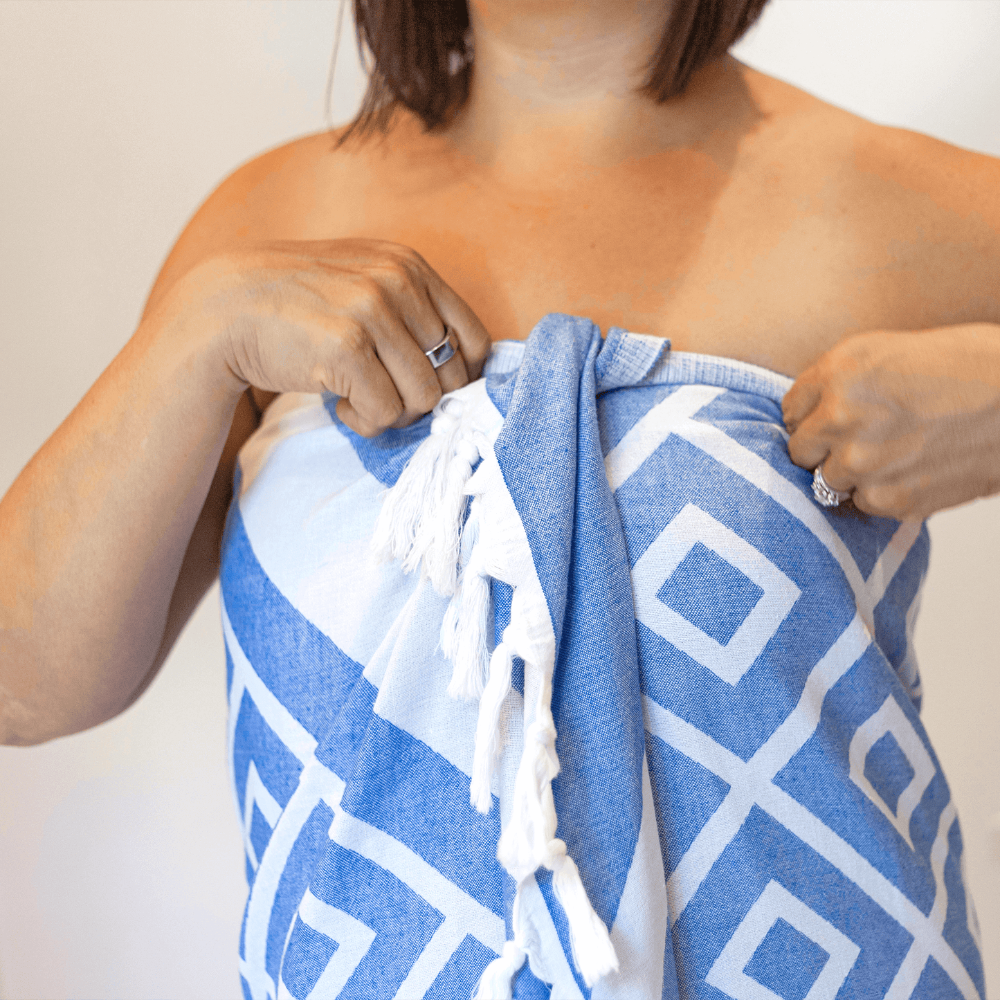 Woman in the bath wearing a white and blue Turkish towel set