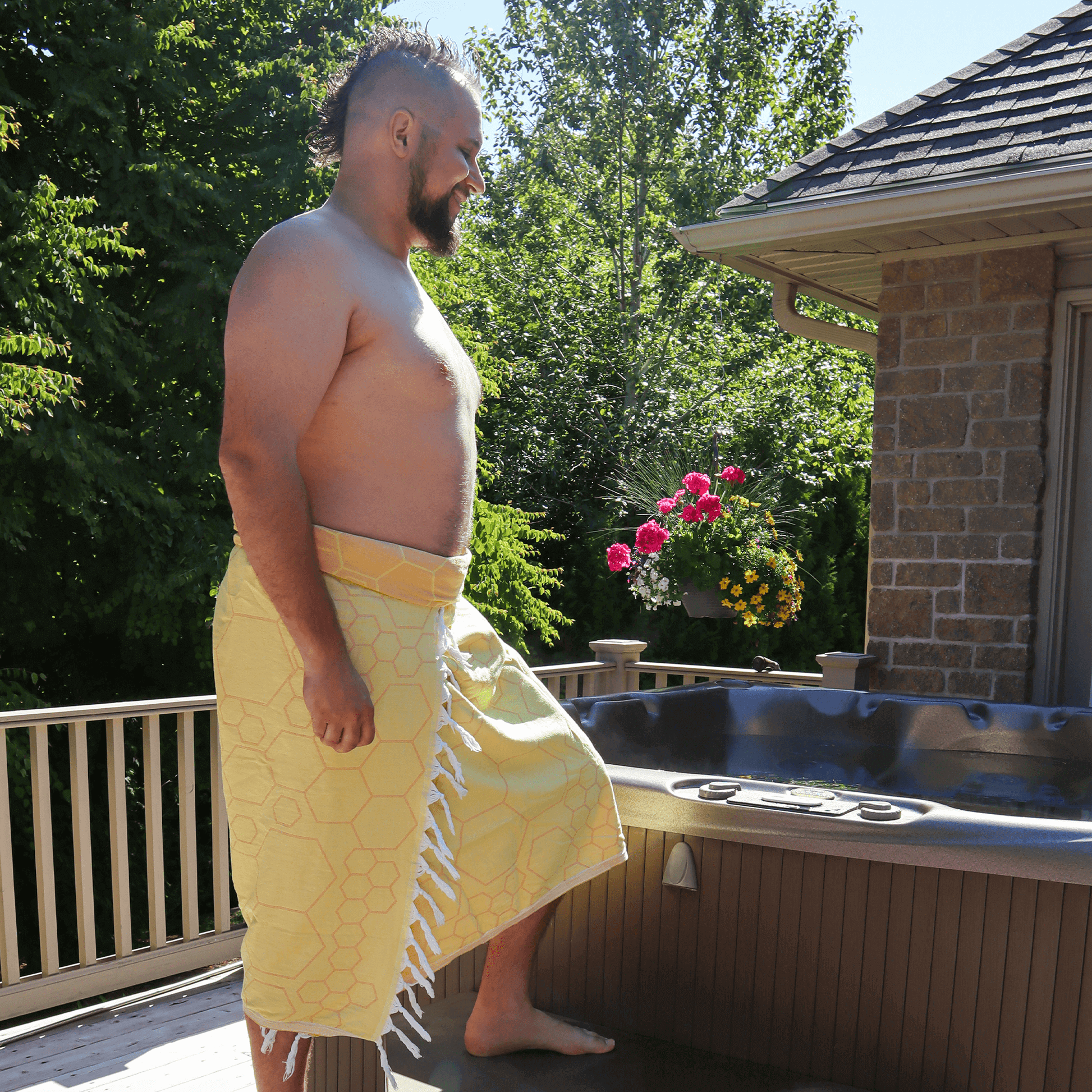 happy man shirtless summer by hot tub wearing a yellow Turkish towel