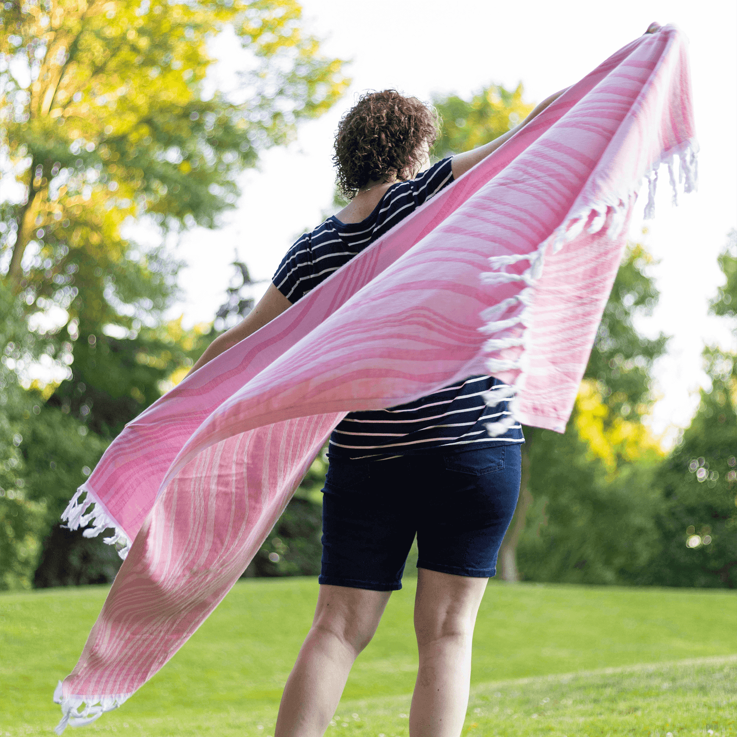 Pink Turkish towel in the summer held by a dancing woman