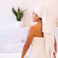 Smiling woman in a white Turkish towel in the bath