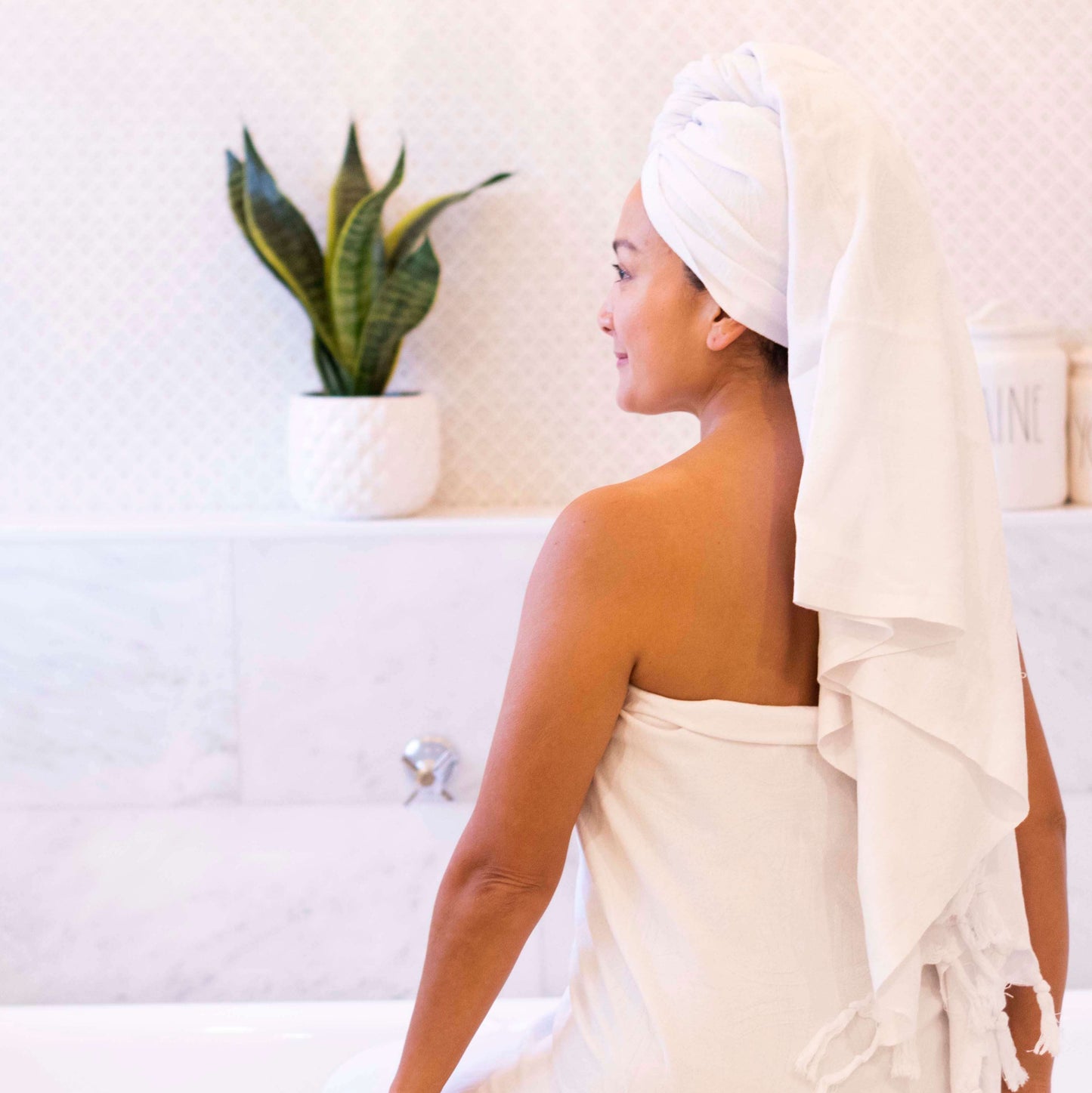 Smiling woman in a white Turkish towel in the bath