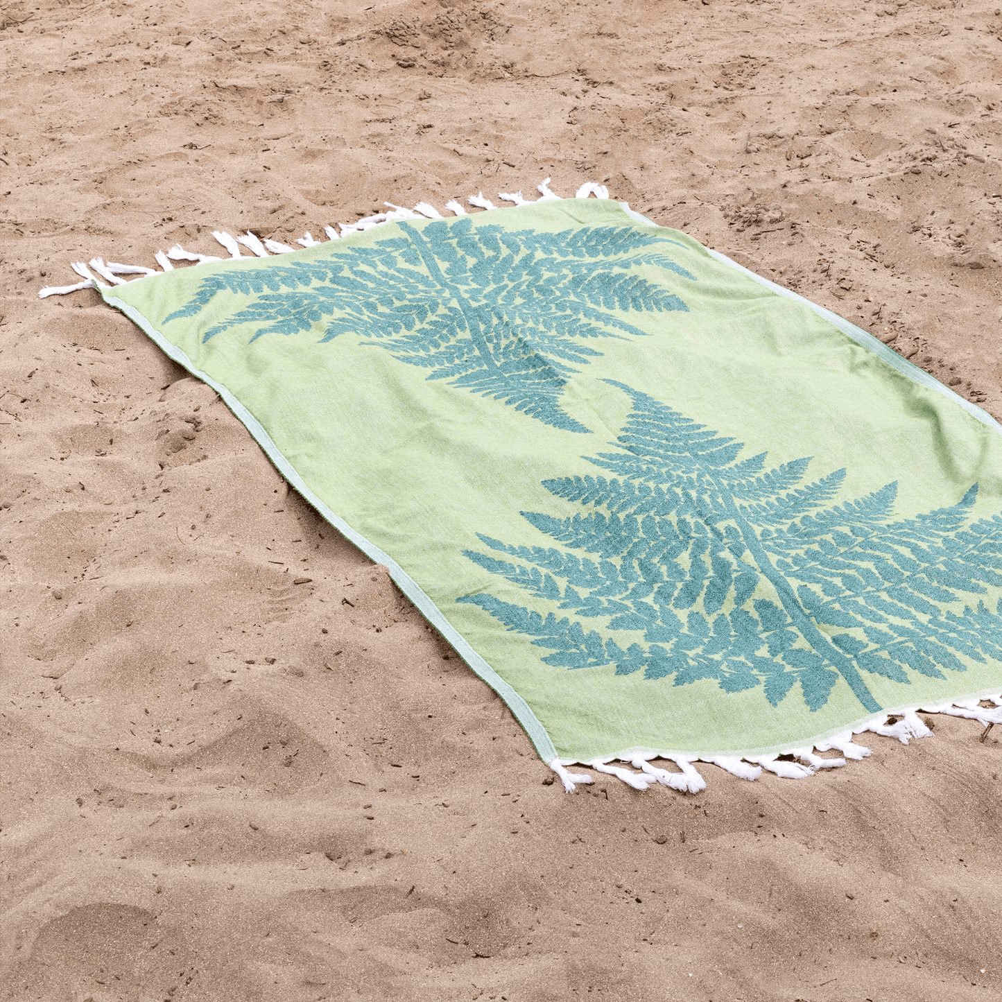 Green Turkish towel at the beach