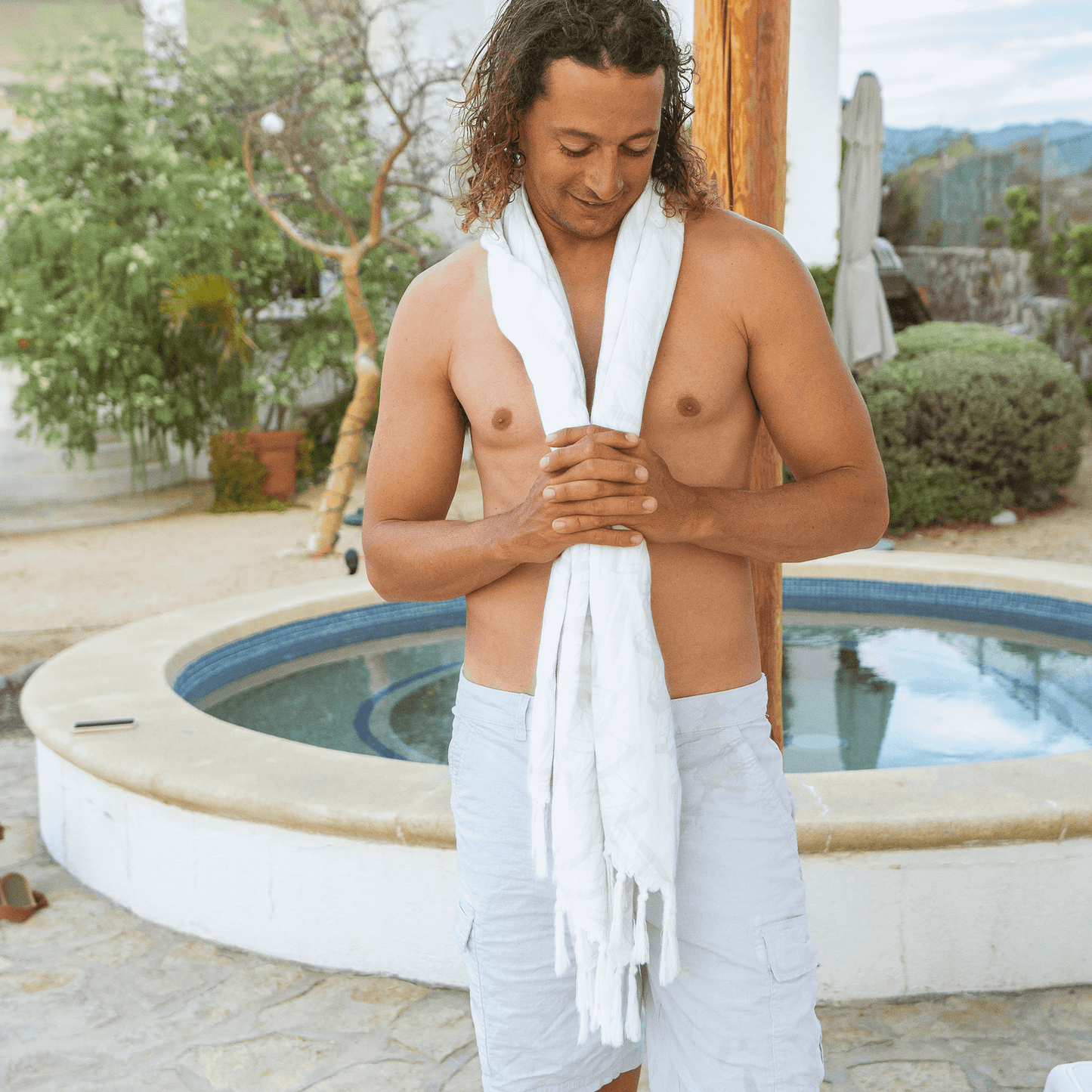 shirtless man using a white Turkish towel at a luxury resort