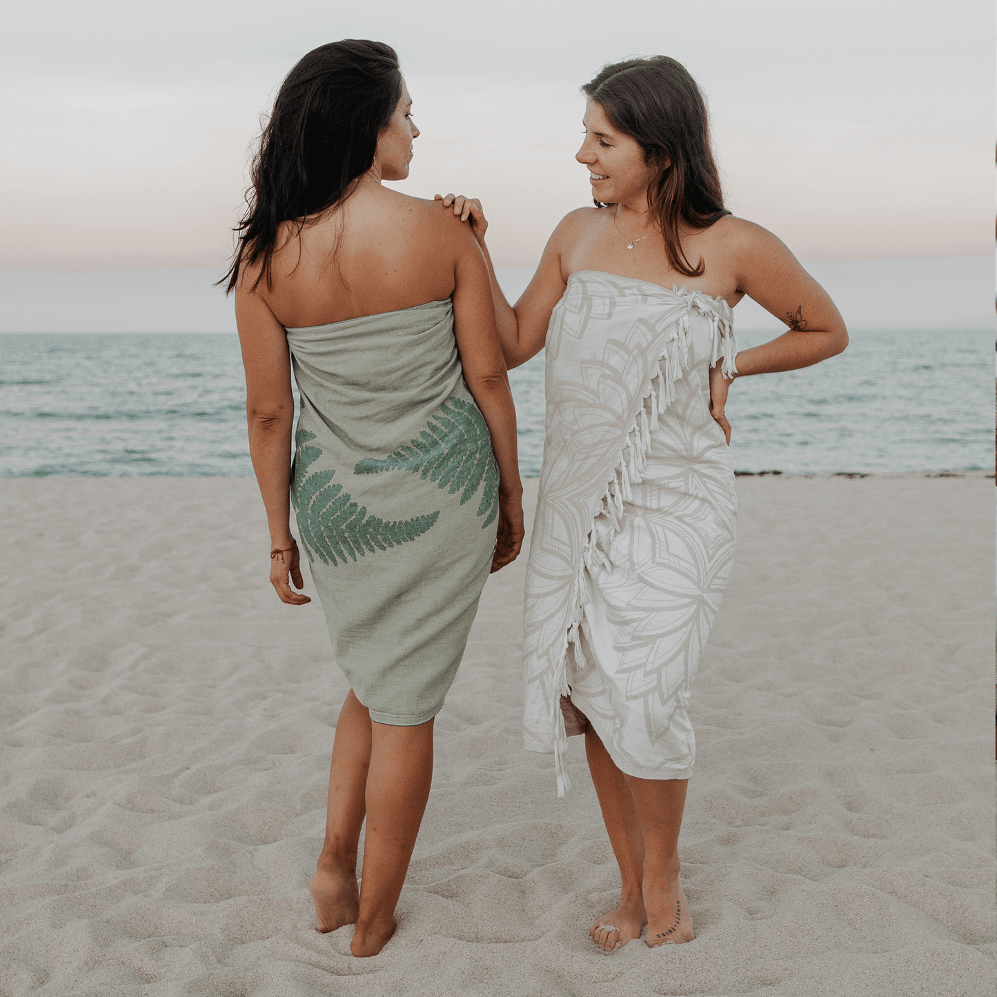 Two women at the beach using Turkish towels as sarongs