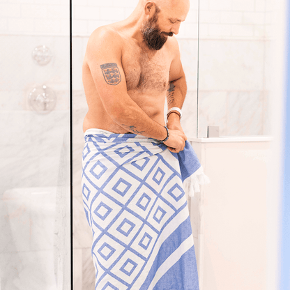 Shirtless man using a Turkish towel in the bath