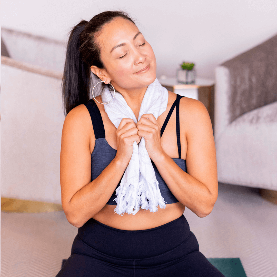 smiling woman using a Turkish towel after yoga