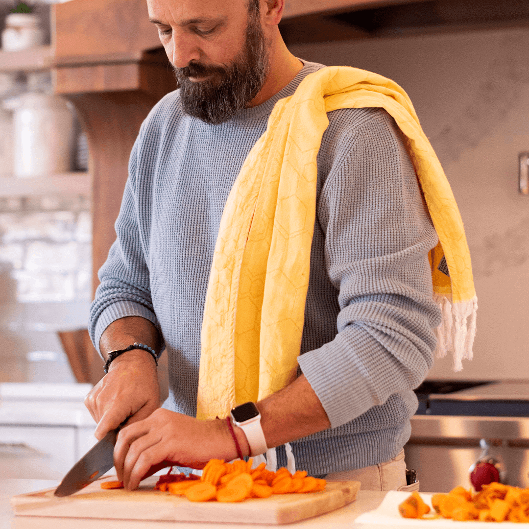 Man in the kitchen using a Yellow Turkish Hand Towel to cook 