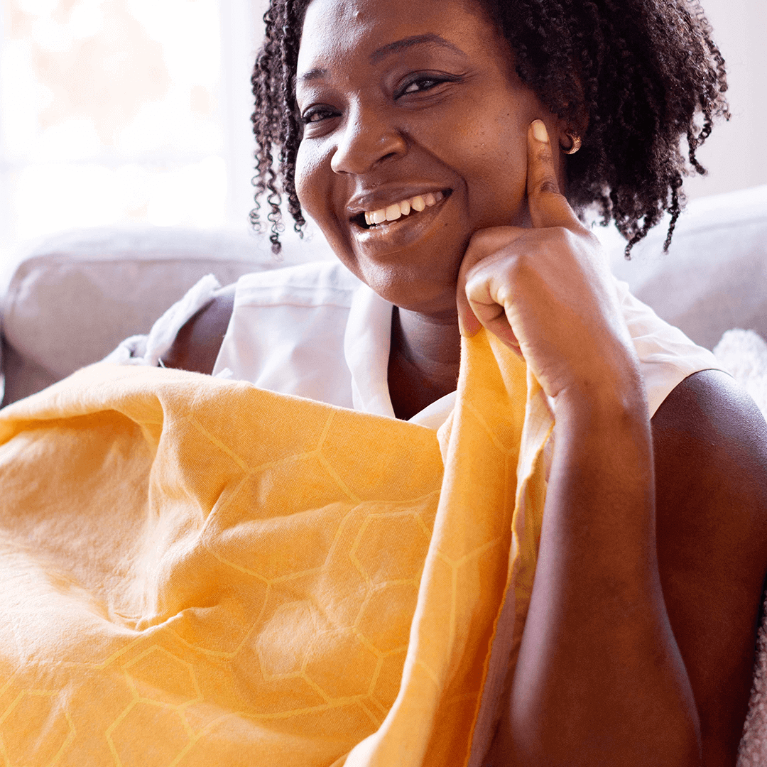 smiling woman using a yellow Turkish towel as a light blanket