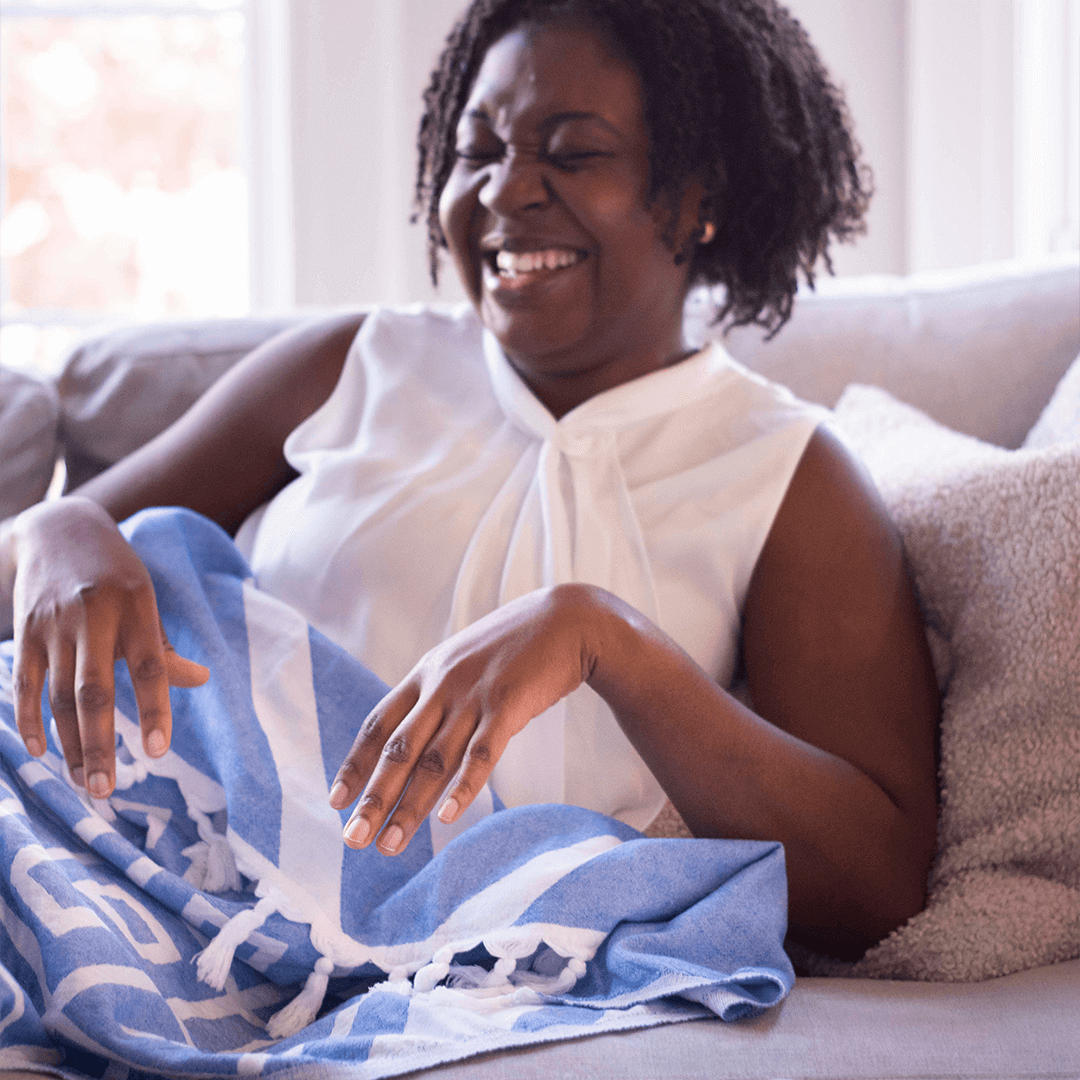 Woman using a blue and white Turkish towels as a blanket