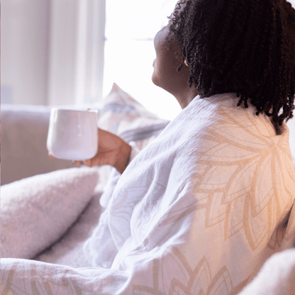 Woman using a Turkish towel as a light blanket white drinking coffee